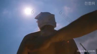 面对着炎炎夏日的阳光，一个男人把<strong>防晒霜</strong>涂在妻子的背上，以防止